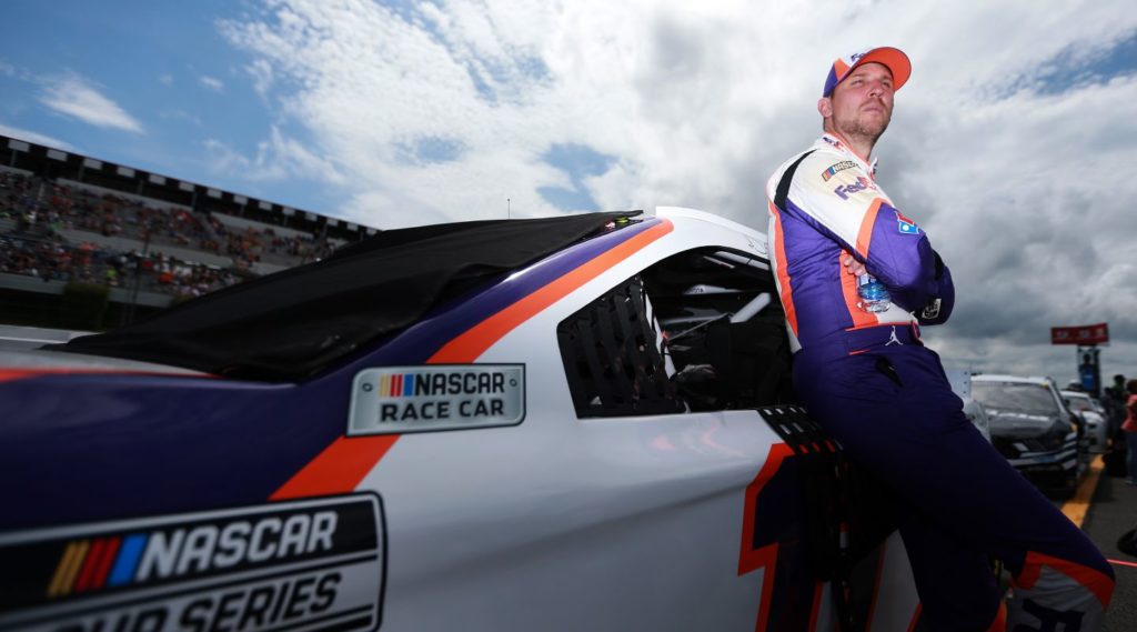 Denny Hamlin leaning next to car at Pocono 2021