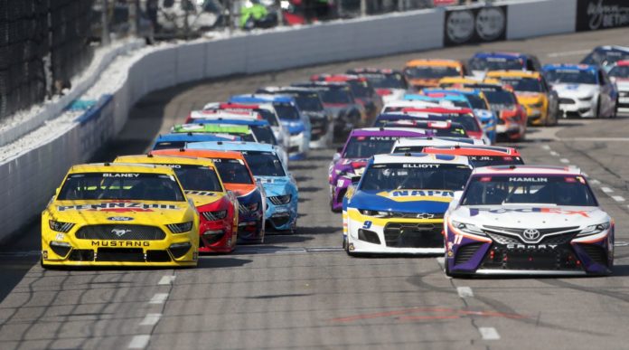 Denny Hamlin, driver of the #11 FedEx Office Toyota, and Ryan Blaney, driver of the #12 Menards/Pennzoil Ford, lead the field to start the NASCAR Cup Series Blue-Emu Maximum Pain Relief 500 at Martinsville Speedway on April 11, 2021 in Martinsville, Virginia.