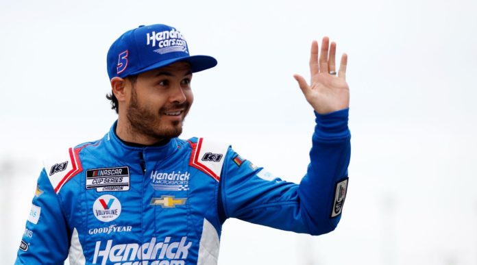 Kyle Larson waving to fans in garage area during practice at Daytona International Speedway